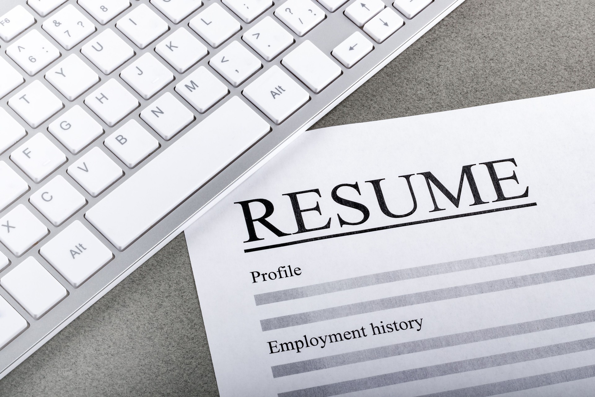 Resume and keyboard on the table closeup.